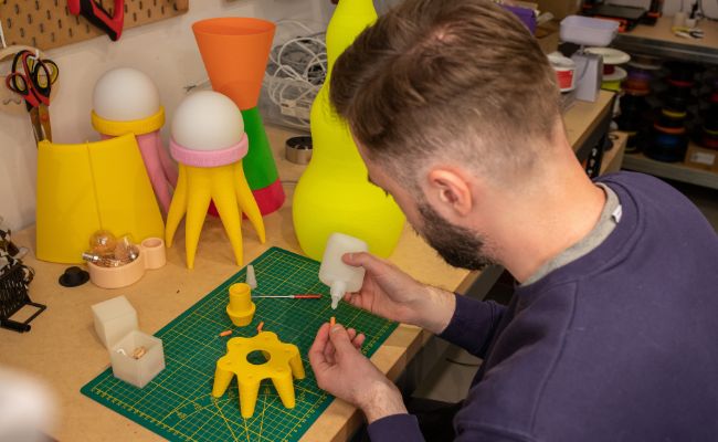designer z Yam yest design pracuje nad swoim produktem - lampą, którą sprzedaje w sklepie internetowym Shoper 