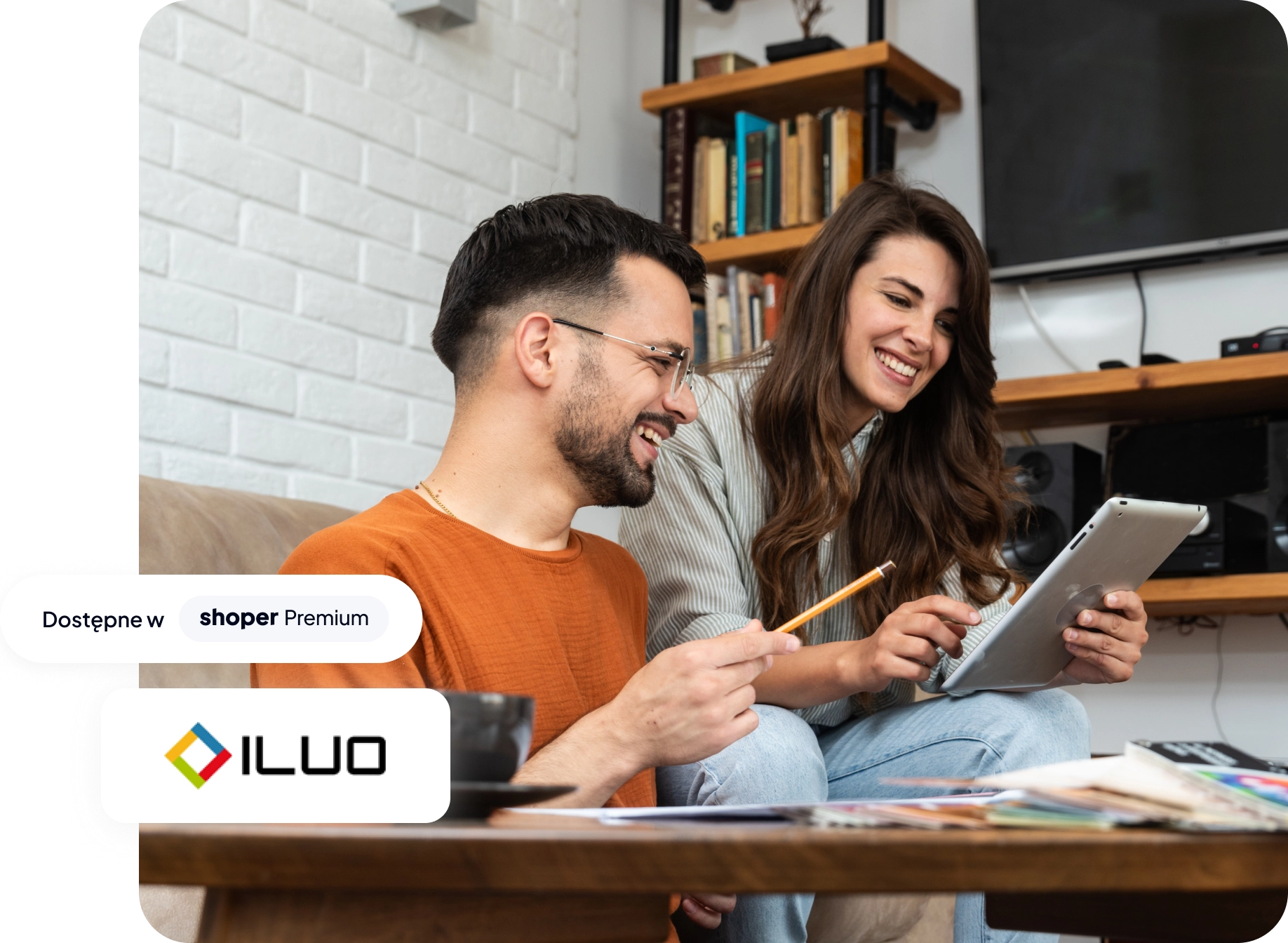 Mężczyzna i kobieta patrzą w tablet, a na grafikę naniesiono jest logo systemu Iluo