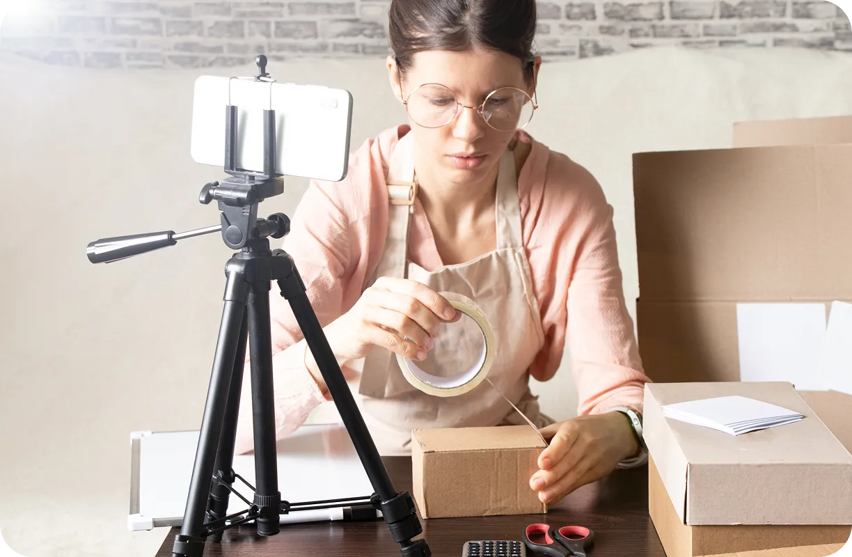 Kobieta pakuje paczkę i zastanawia się, jak zacząć dropshipping