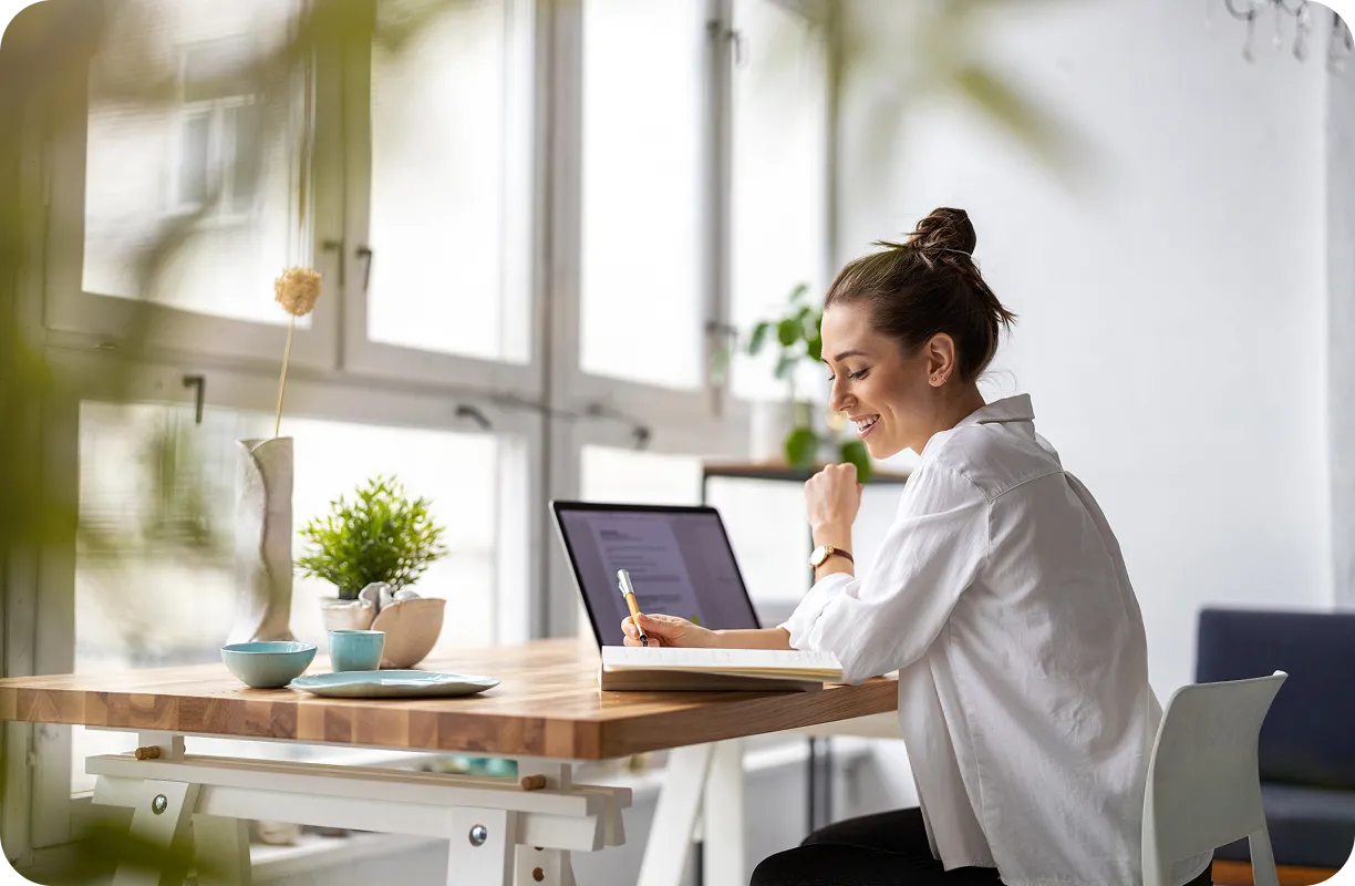 Kobieta siedzi przy biurku i zakłada sklep do dropshippingu